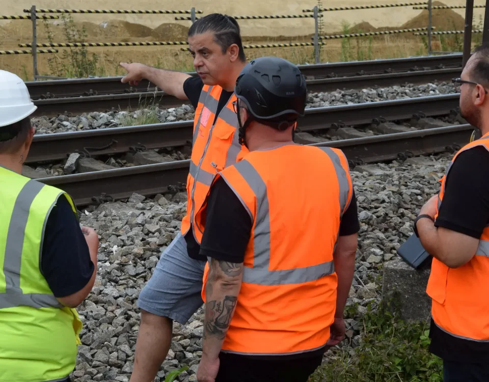 SDL-Team beim Ortstermin an einer Bahnstrecke mit fester Absperrung